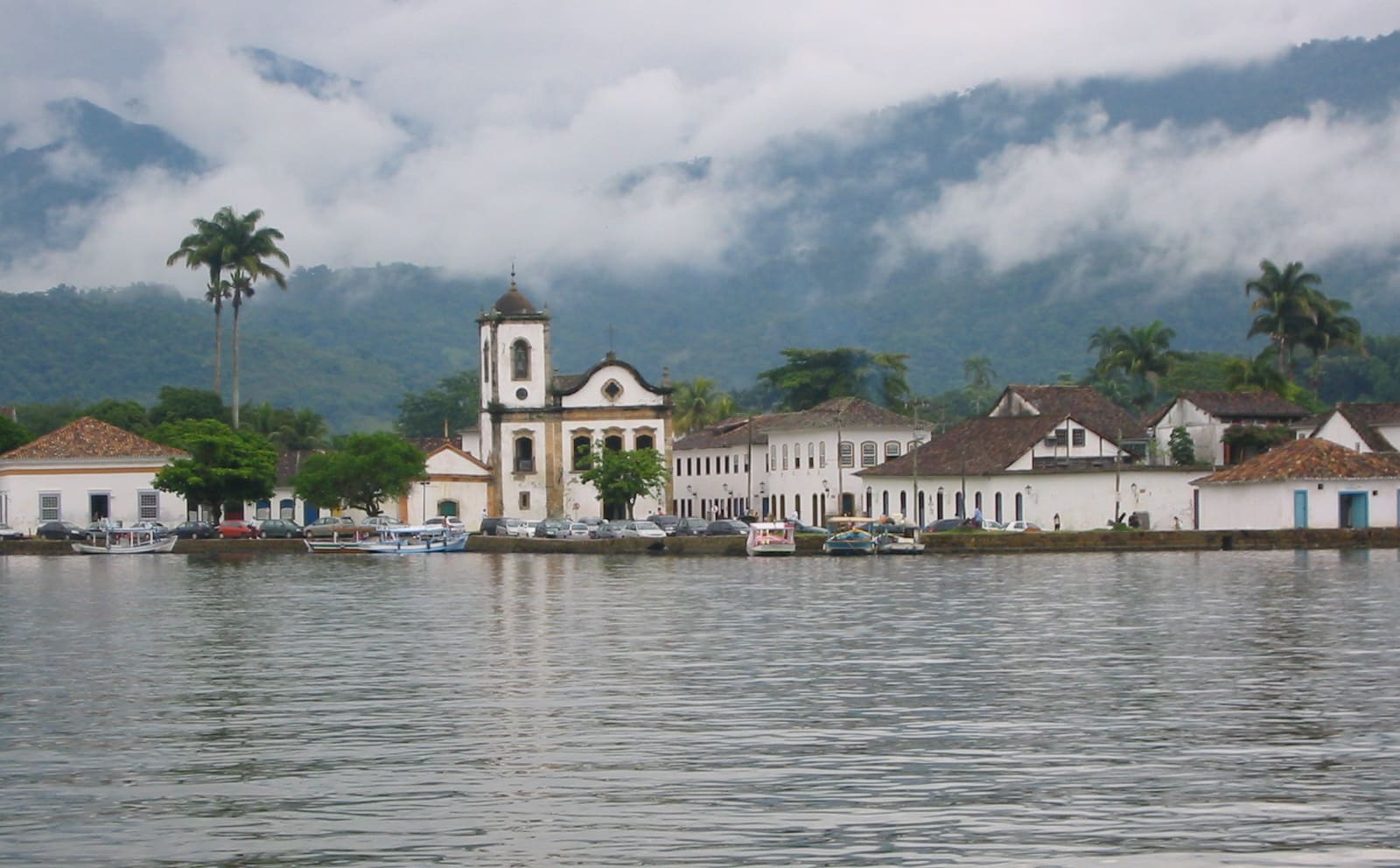 Rua de pedras do centro histórico de Paraty com casario colonial branco e portas coloridas